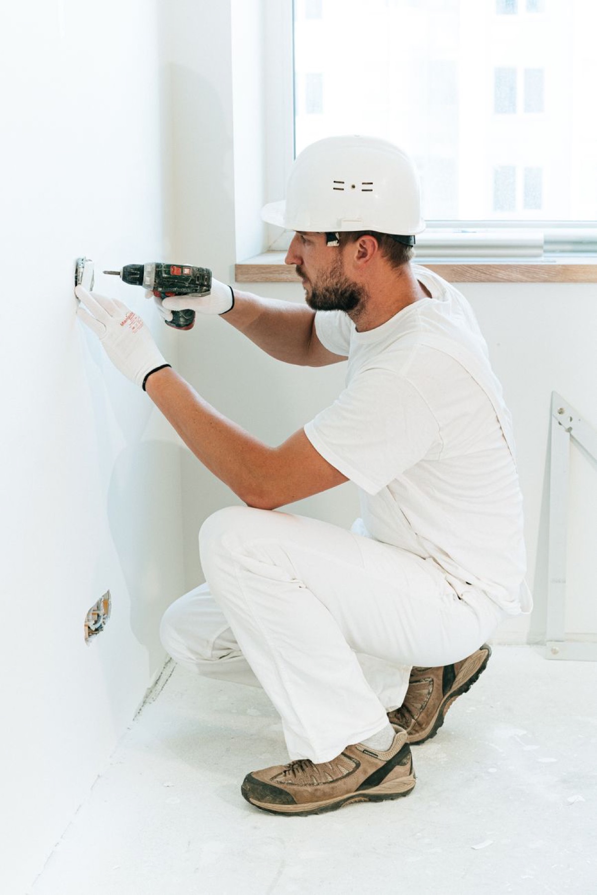 An electrician installing an outlet in a finished wall