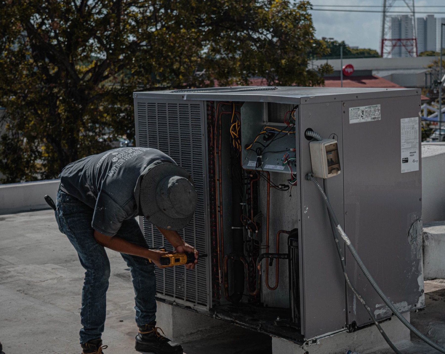 An HVAC technician servicing outdoor equipment