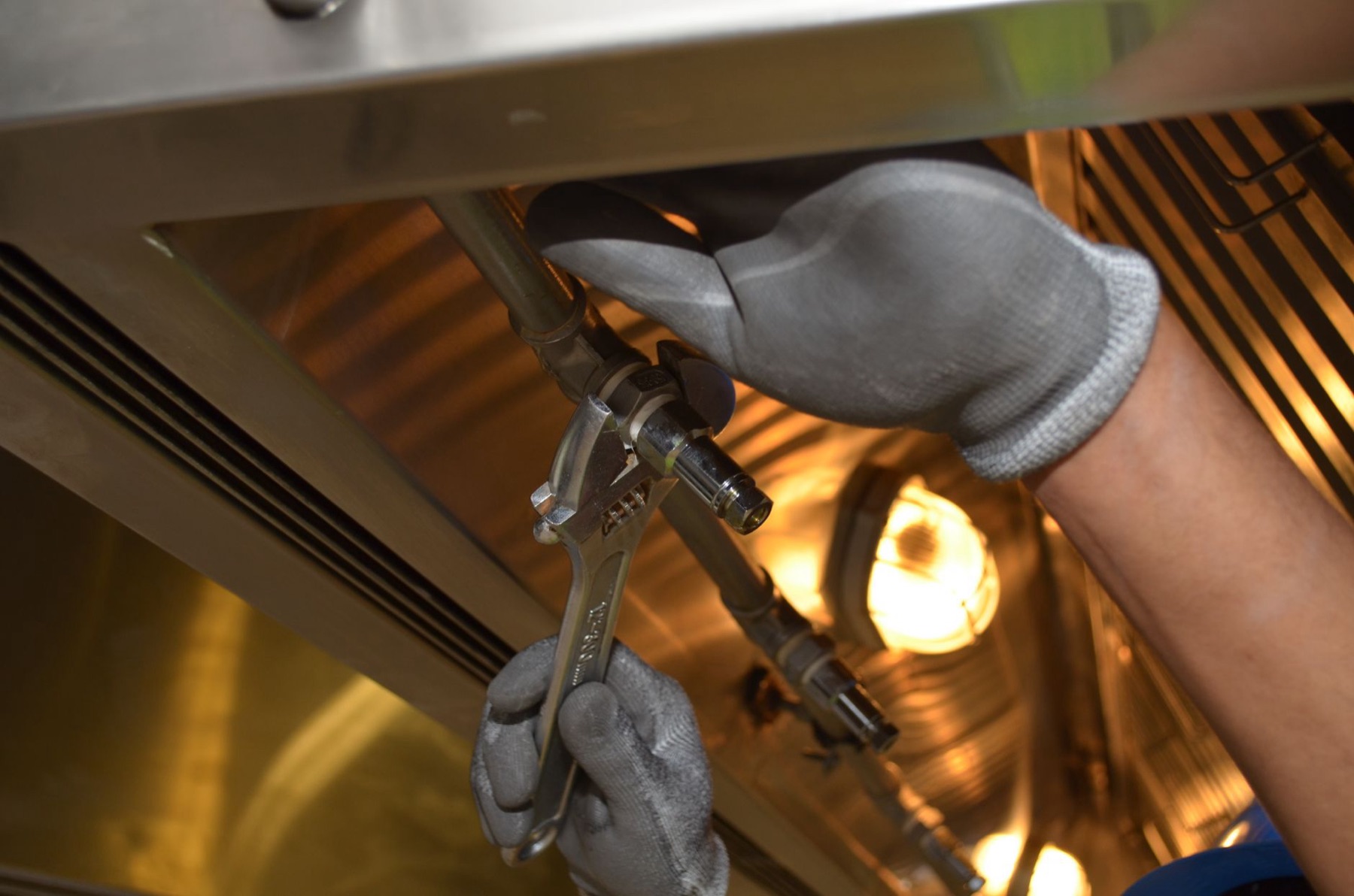A worker fixing pipes with tools indoors