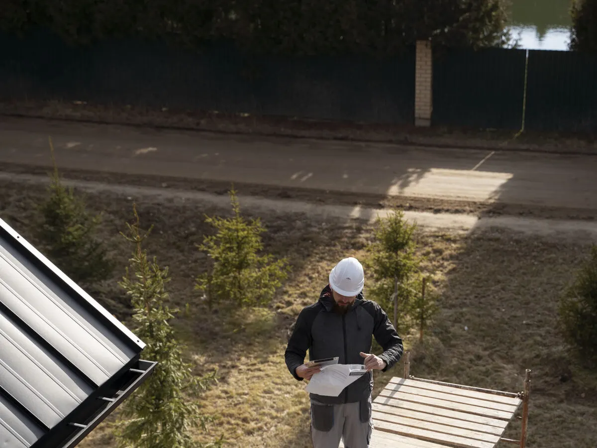 Roofer reviewing plans on a job site